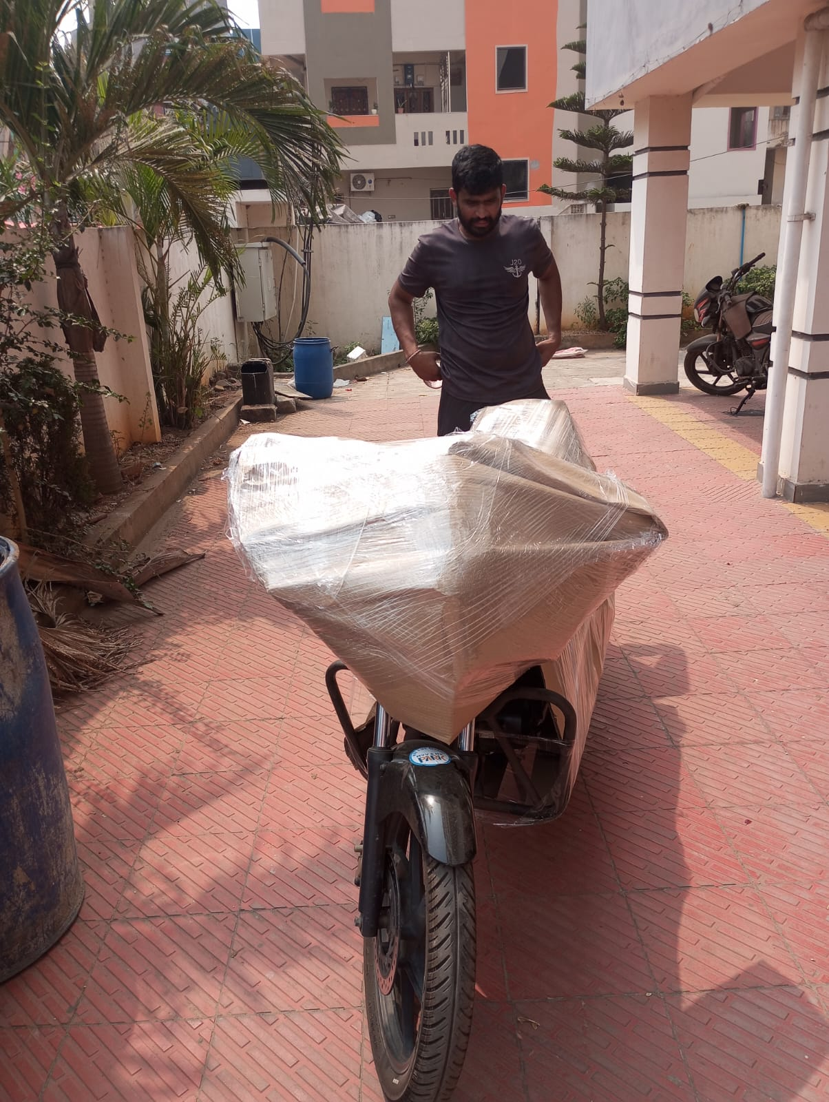 Kalyan Packers crew wrapping a two-wheeler for safe transport